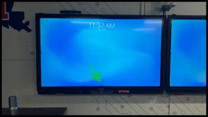 Photo of the left ActivPanel screen with an arrow pointing to the bottom center of the screen where a ^ is located.